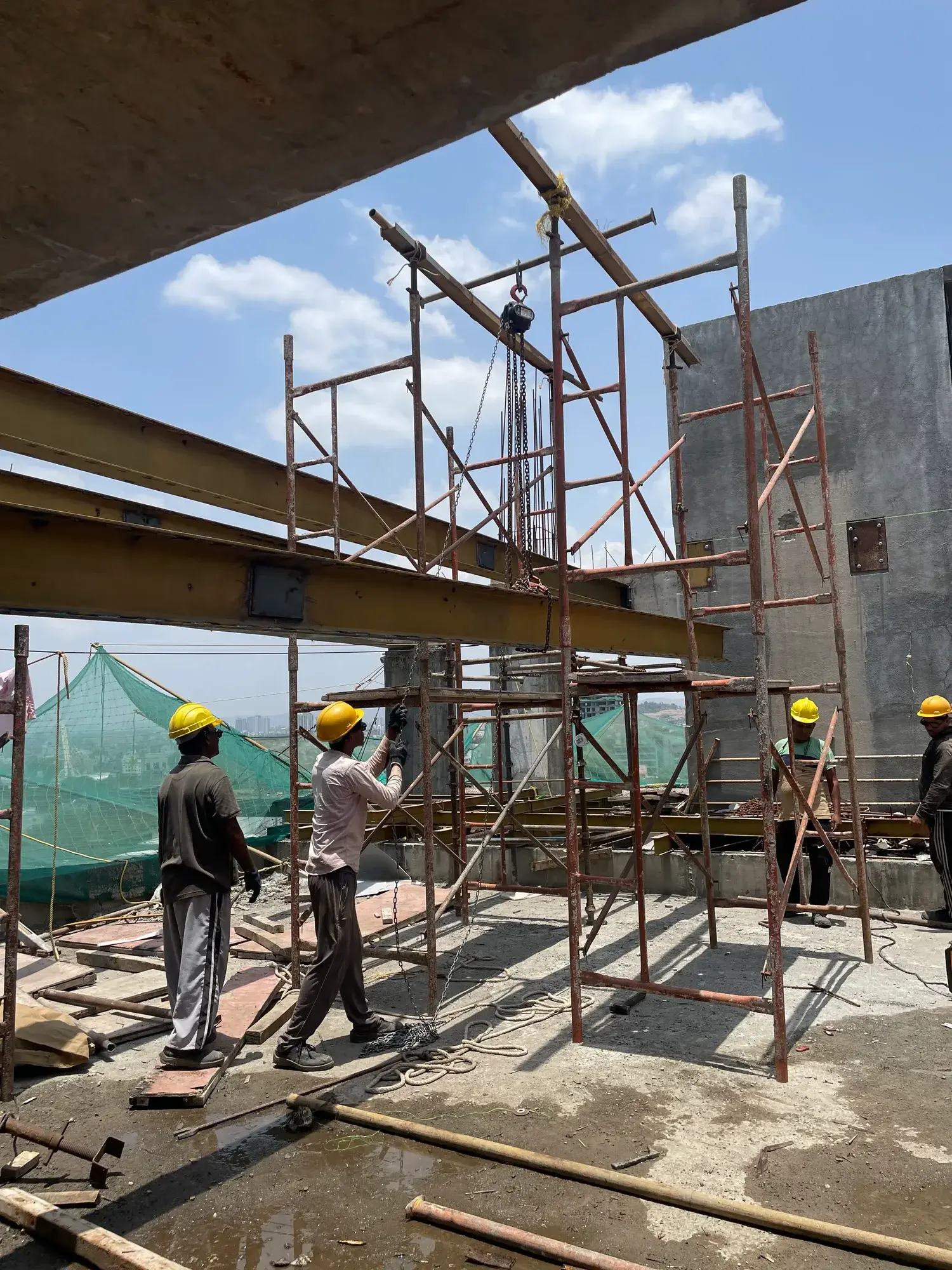 Hoisting a deck beam into position at Kalpvishwa